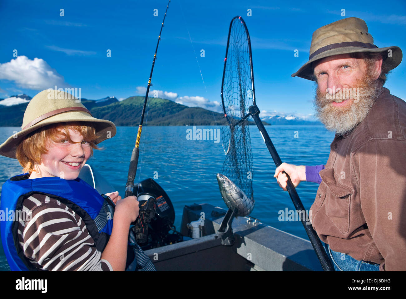 Teenage Boy et grand-père pour la pêche du saumon d'argent à partir d'un bateau dans la baie du Prince William Southcentral Alaska Banque D'Images