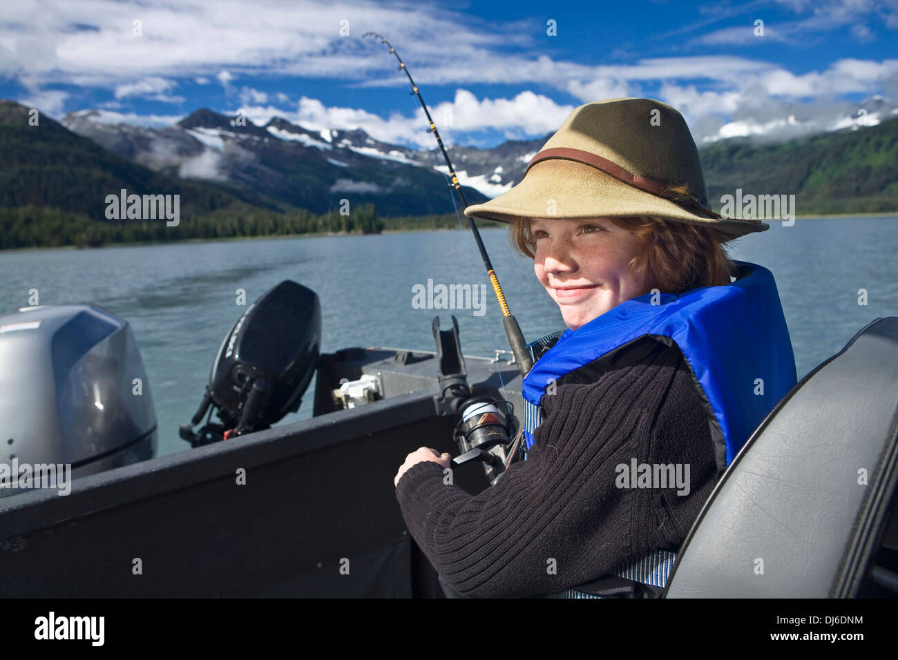 Adolescent assis sur un bateau de pêche pour le saumon d'argent à Prince William Sound, Southcentral Alaska. Banque D'Images