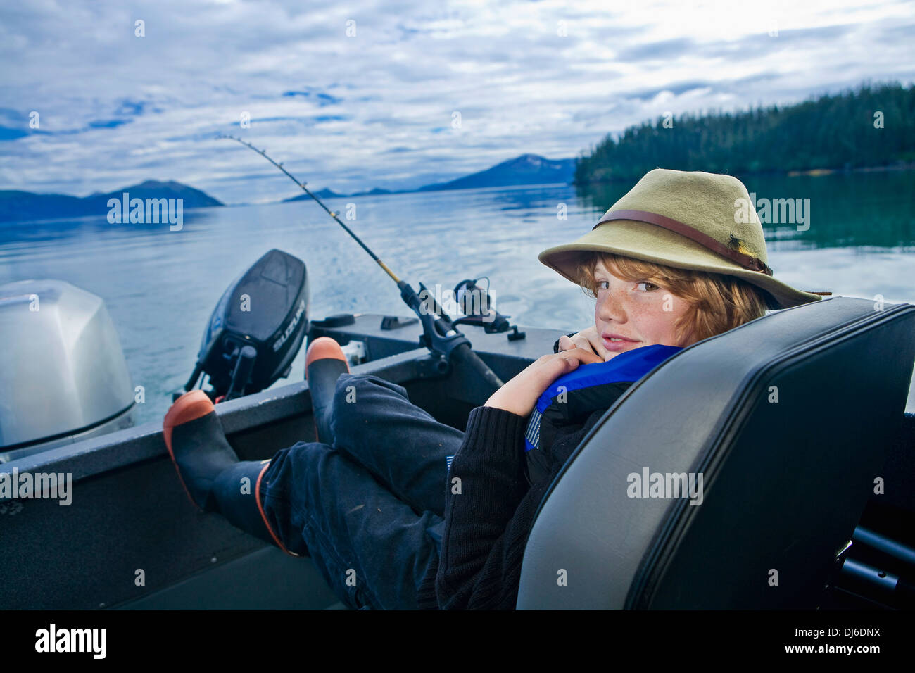 Adolescent assis sur un bateau de pêche pour le saumon d'argent à Prince William Sound, Southcentral Alaska. Banque D'Images