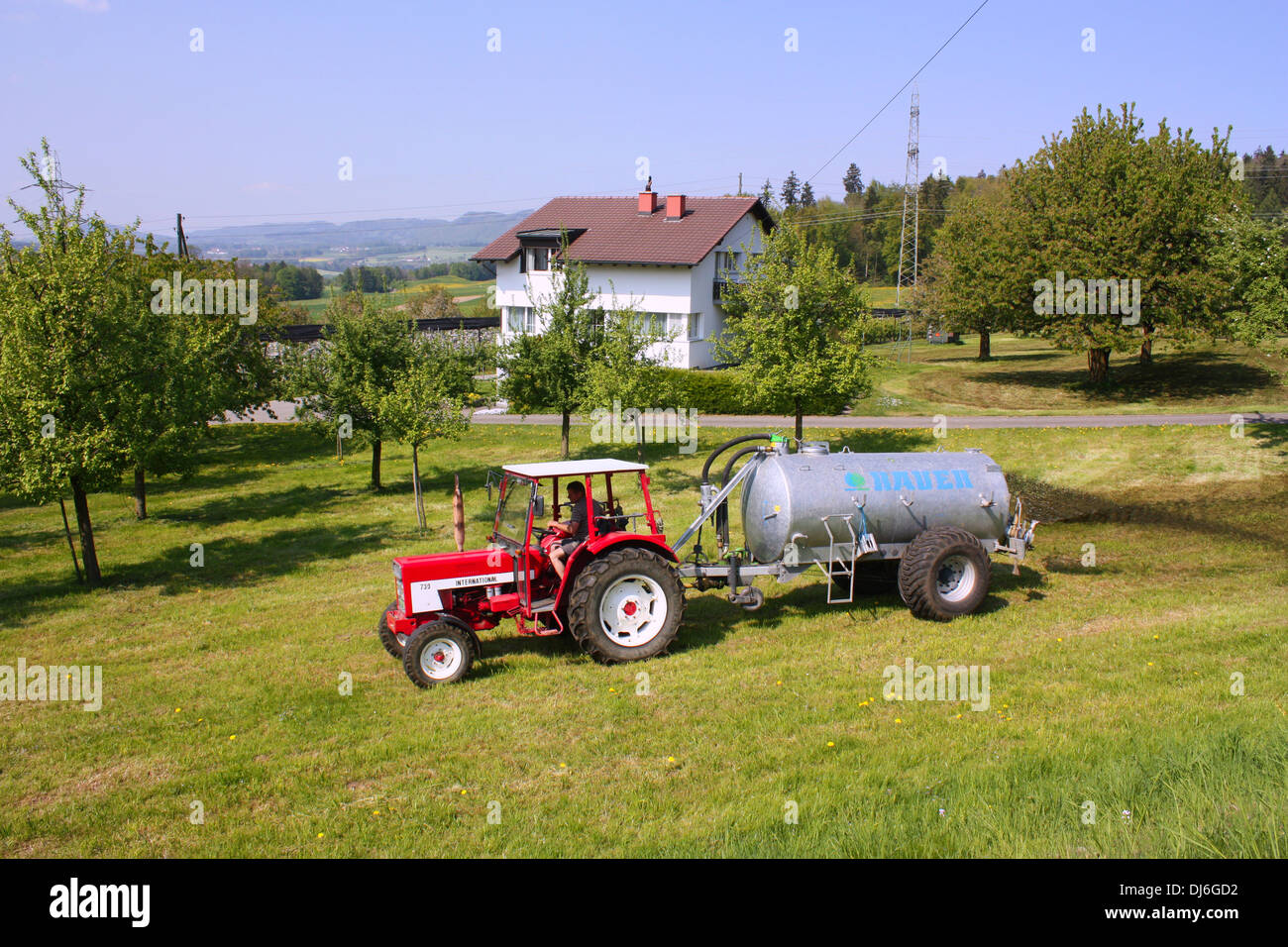 Le tracteur dans le champ vert en Suisse Banque D'Images