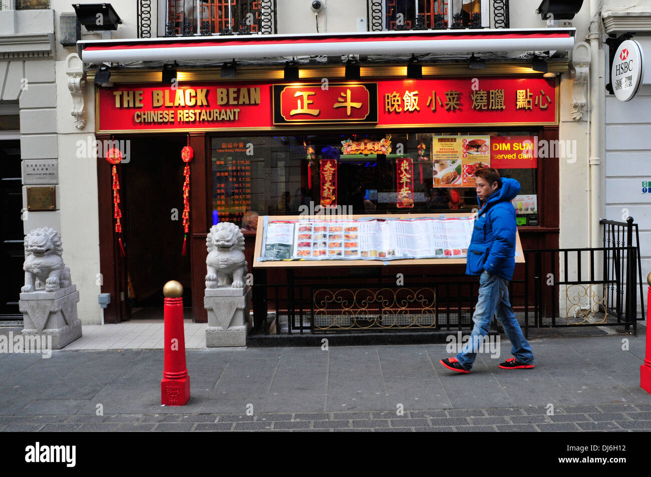Un homme passe devant le restaurant de haricots noirs dans China Town, Londres. Banque D'Images