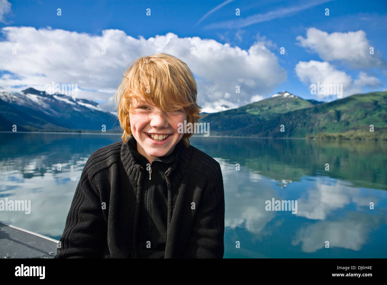 Adolescent est assis dans un petit bateau de pêche dans le Prince William Sound, Southcentral Alaska Banque D'Images
