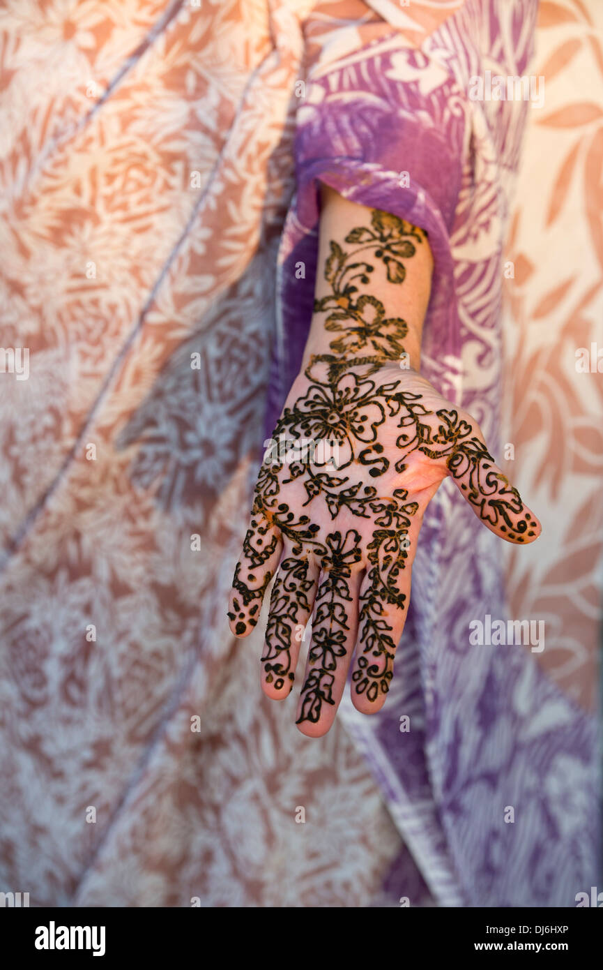 Appliquer le henné sur dyying une main contre un sari. L'Inde Banque D'Images