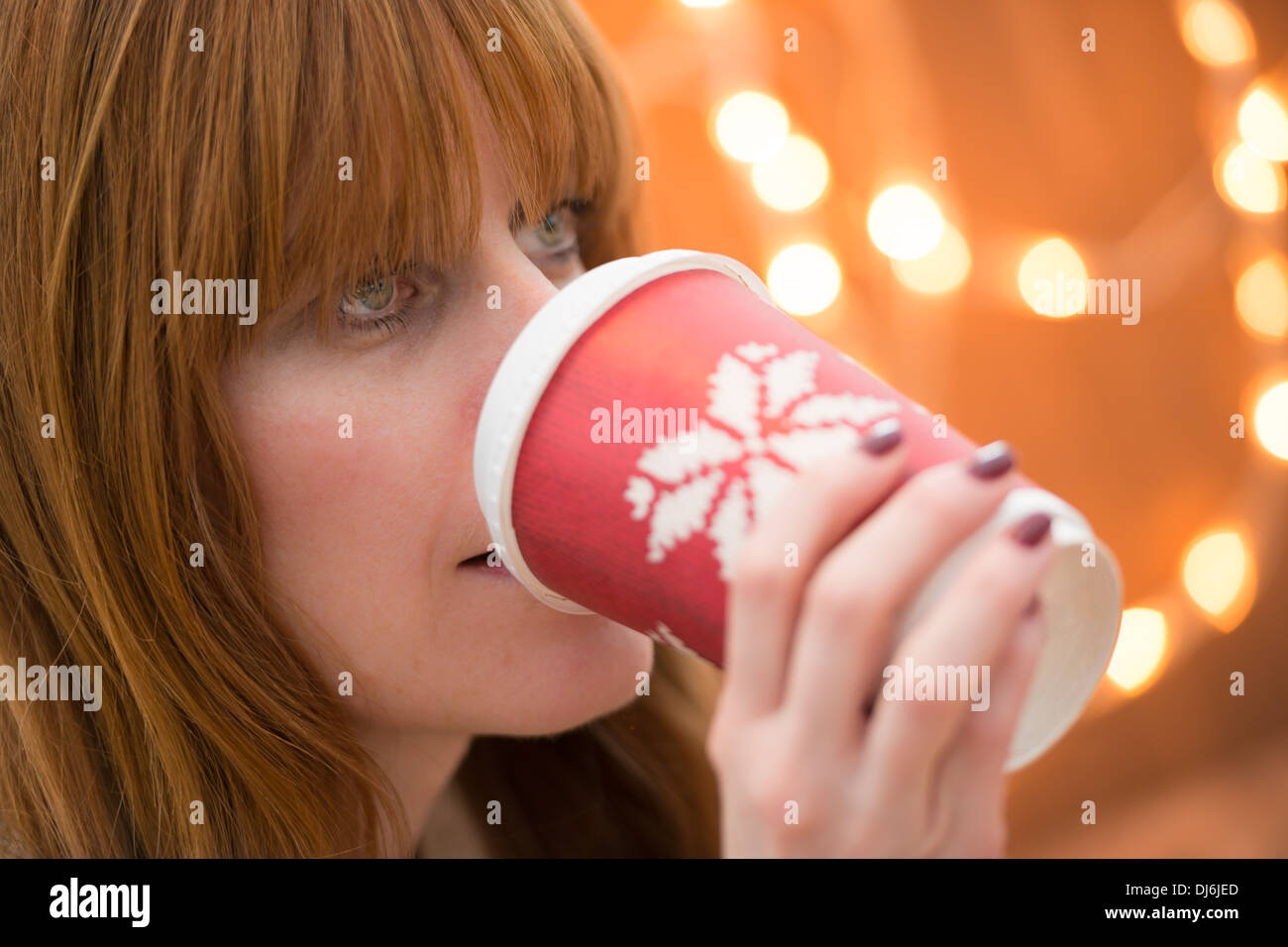 Femme buvant une boisson festive à l'époque de Noël Banque D'Images