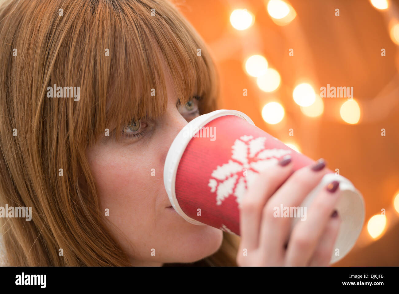 Femme buvant une boisson festive à l'époque de Noël Banque D'Images