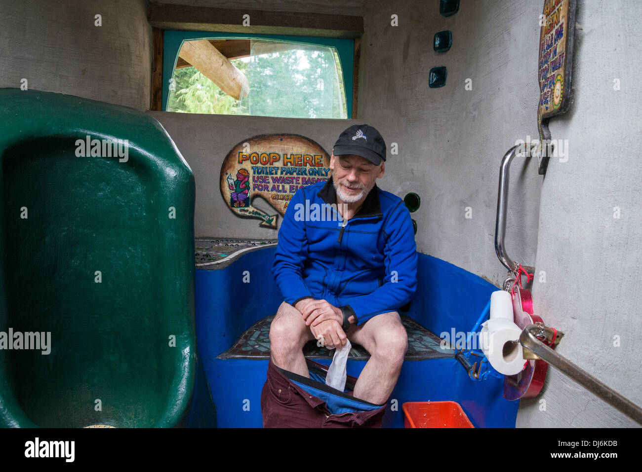 Homme utilisant des toilettes à compost, Hornby Island, Colombie-Britannique, Canada Banque D'Images