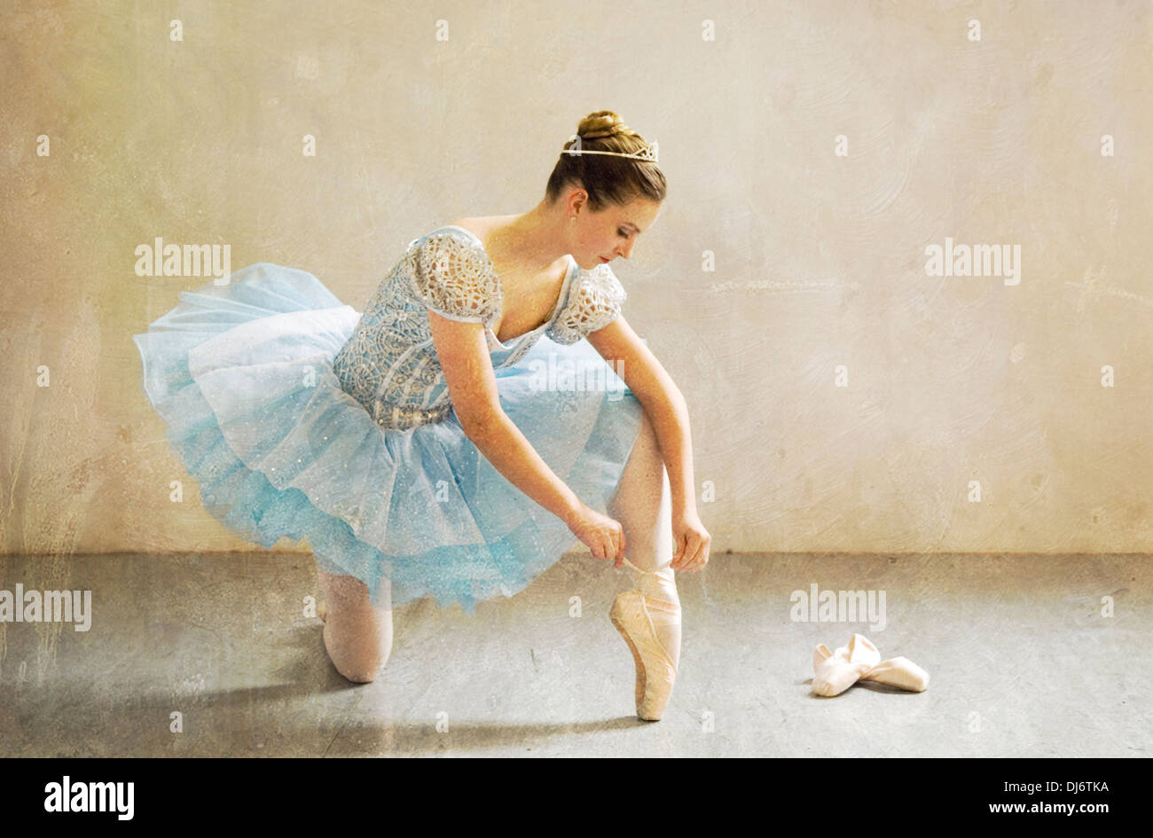 Young Ballerina assis sur le plancher d'un liage Studio Son Ballet Chaussons Banque D'Images