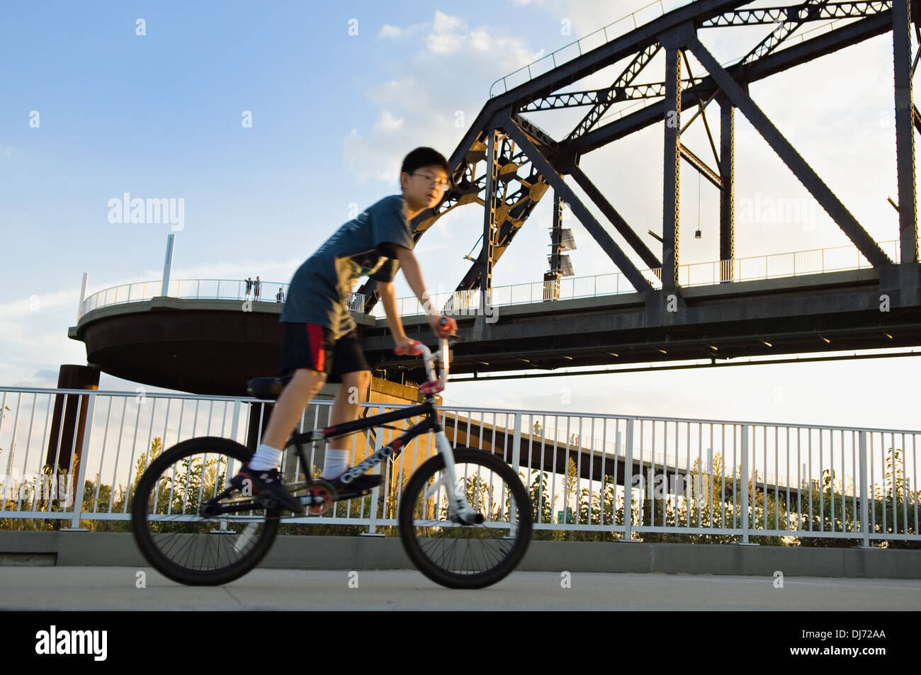 Boy Riding Bicycle jusqu'à la passerelle pour piétons à Louisville Banque D'Images