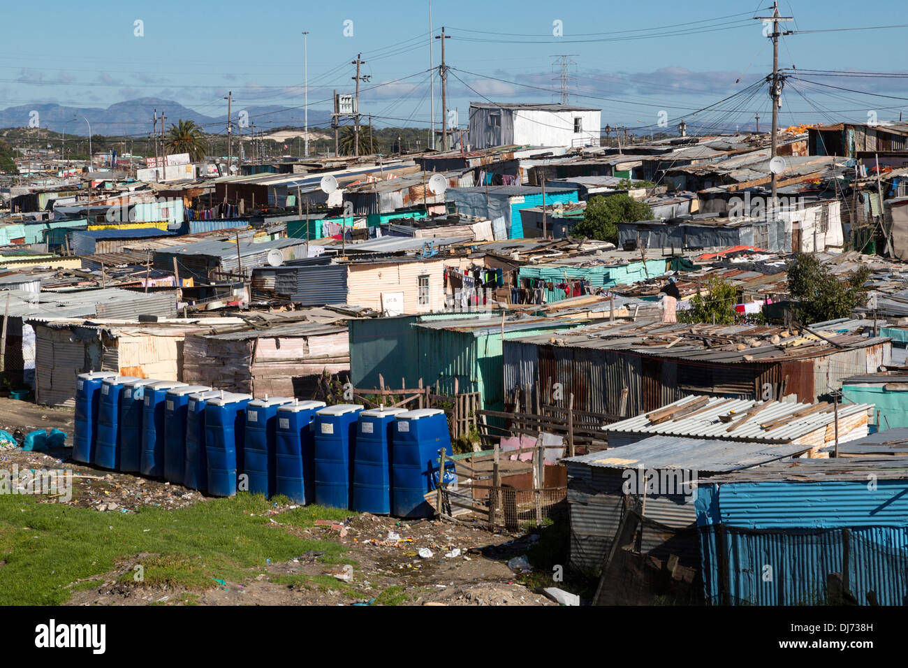 L'Afrique du Sud, Cape Town, township de Khayelitsha. Des toilettes portables bleu en premier plan. Banque D'Images