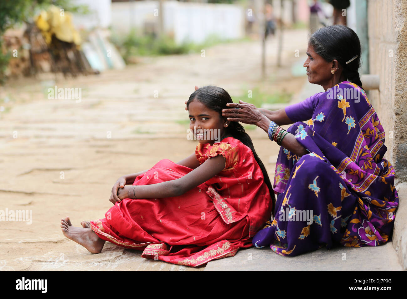 Grand mère faire les cheveux de sa petite fille l'Andhra Pradesh, Inde Banque D'Images