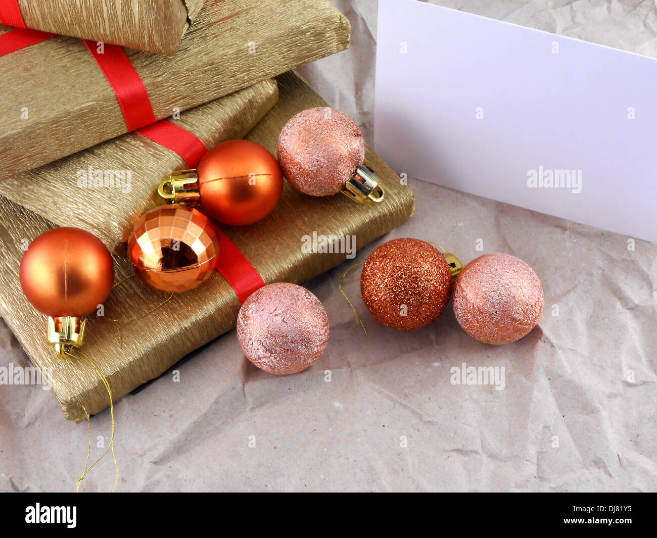 Coffret cadeau doré avec ruban rouge, des boules de noël et carte vide Banque D'Images