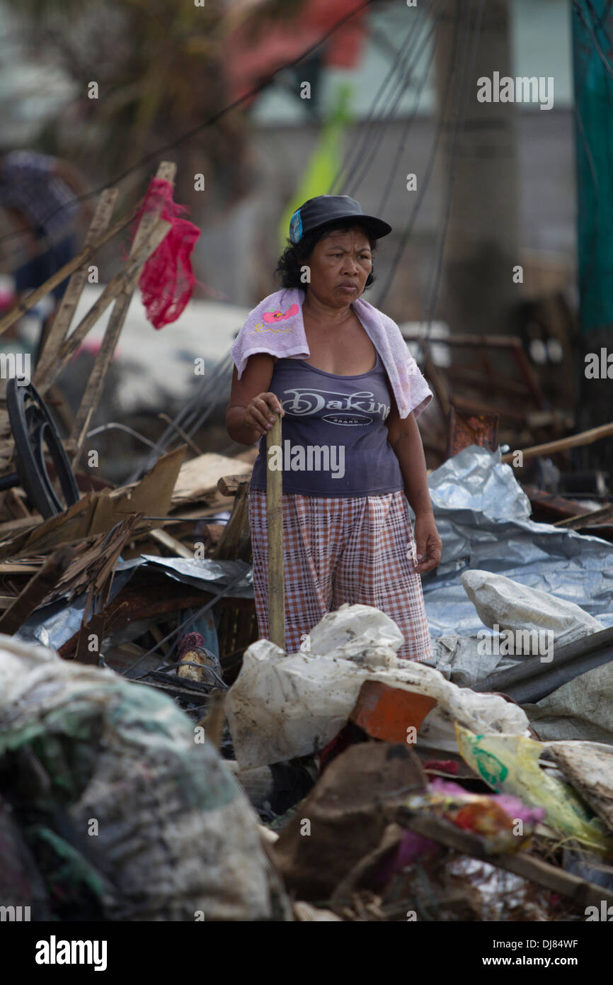 La ville de Tacloban, Philippines. 21 nov., 2013. Les résidents de Tacloban City sont laissés tenter de sauver tout ce qu'ils peuvent à la suite de Typhon Haiyan/Yolanda. Beaucoup sont la reconstruction, la fourniture d'abris provisoires pour leurs familles.ici un regard de womans reflète le défrichage de l'énorme quantité de débris laissés dans le sillage du typhon. Credit : gallerie2/Alamy Live News Banque D'Images