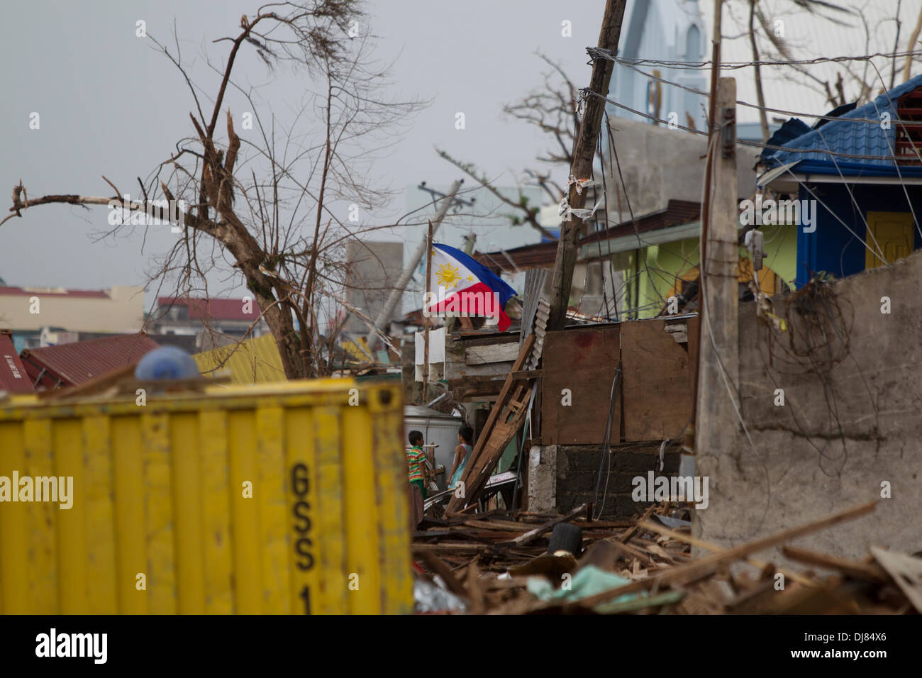 Les résidents de Tacloban City sont laissés tenter de sauver tout ce qu'ils peuvent à la suite de Typhon Haiyan/Yolanda. Beaucoup sont la reconstruction si elles le peuvent, la fourniture d'abris provisoires pour leurs familles.Tout retrait de l'immense quantité de débris est une énorme tâche. Ici la Philippine National drapeau symbolise la force et l'esprit de la communauté locale. Banque D'Images