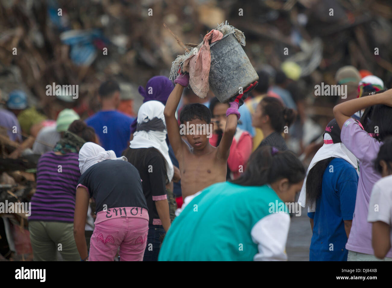 Les résidents de Tacloban City sont laissés tenter de sauver tout ce qu'ils peuvent à la suite de Typhon Haiyan/Yolanda. Beaucoup sont la reconstruction s'ils peuvent fournir un abri temporaire pour leurs familles.Tout retrait de l'immense quantité de débris est une tâche énorme.C'est un travail que tous sont impliqués dans la communauté, jeunes et vieux. Banque D'Images