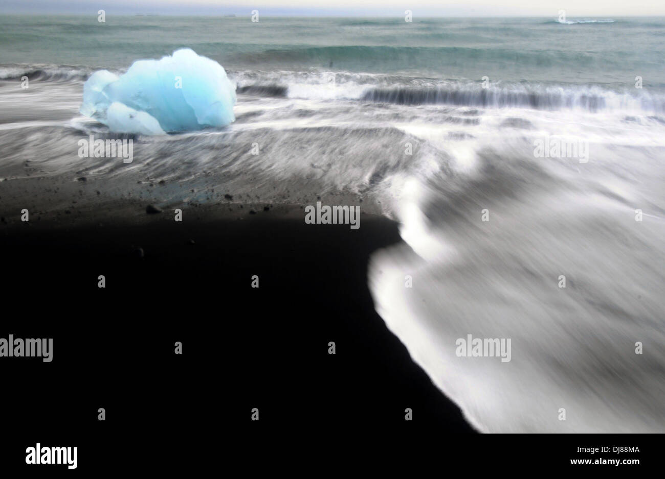 Les icebergs glaciaire à venir à terre par le biais de surf sur une plage de sable volcanique noir, Jokulsarlon, Parc national du Vatnajökull, Islande Banque D'Images