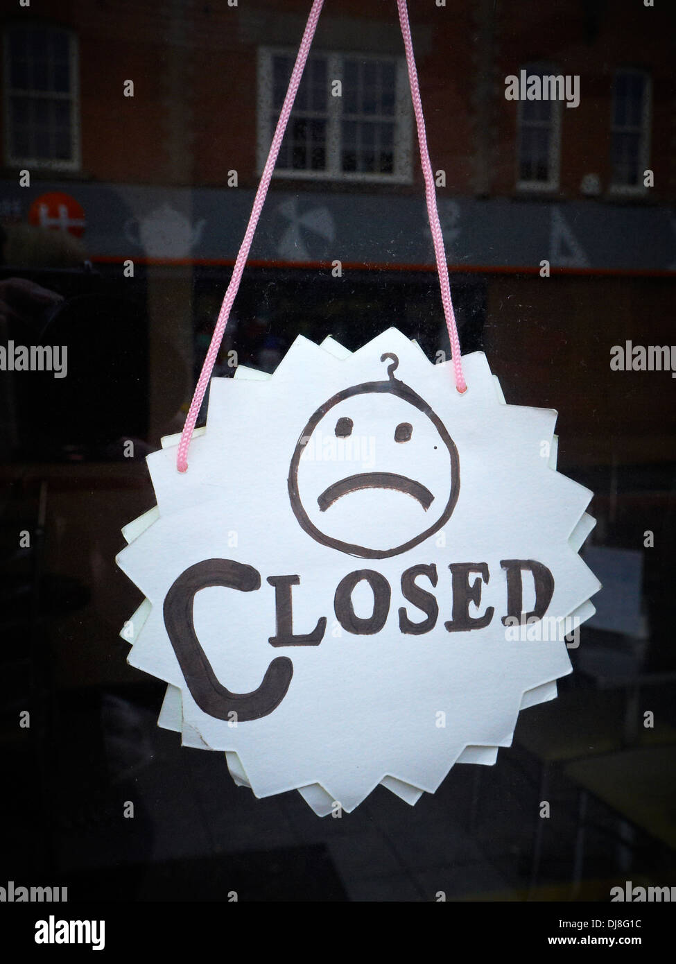 Panneau fermé fait maison sur la porte du magasin avec triste smiley Royaume-Uni Banque D'Images