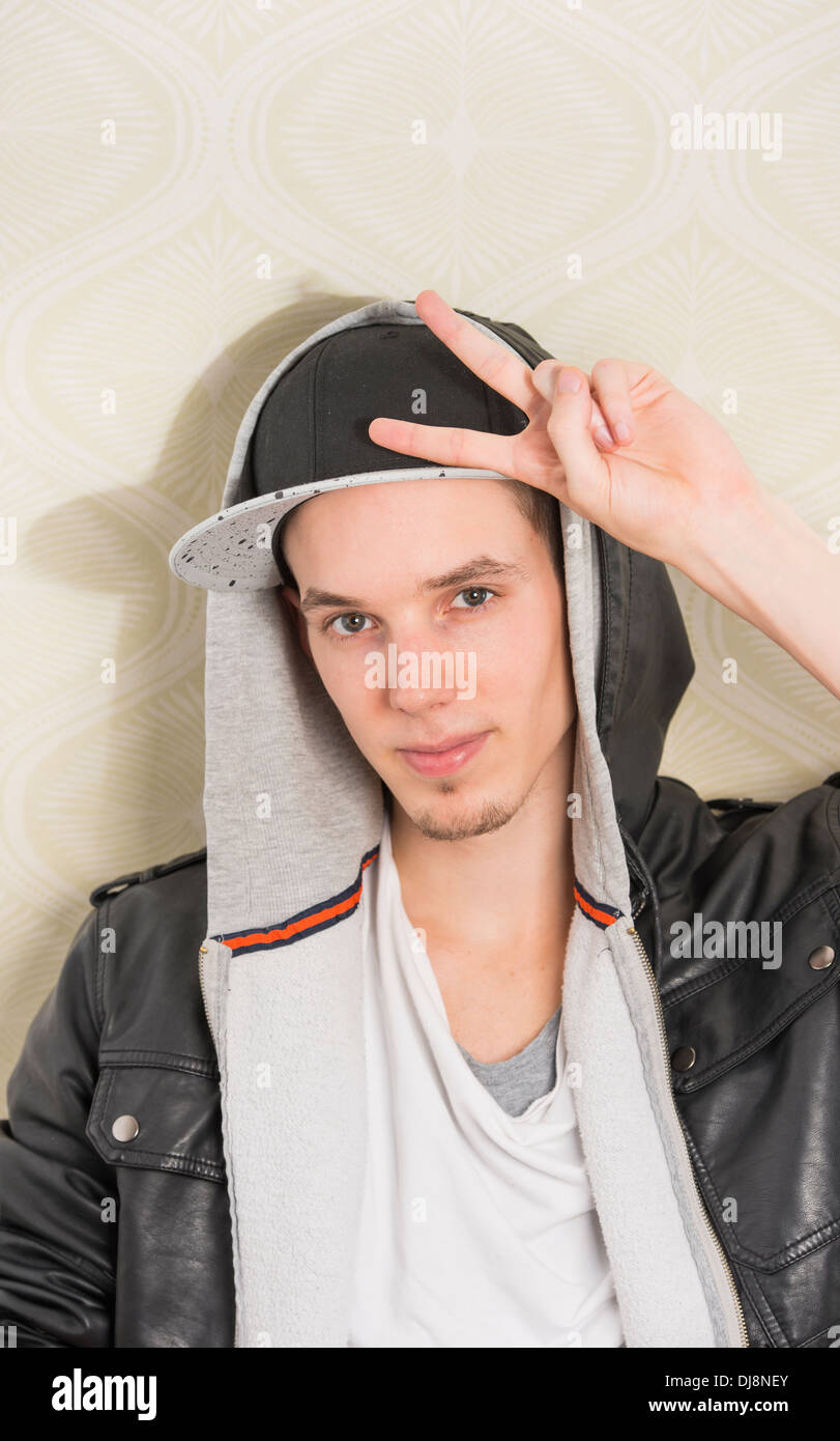 Jeune homme à la cool attitude faisant un signe de la paix avec sa main Banque D'Images