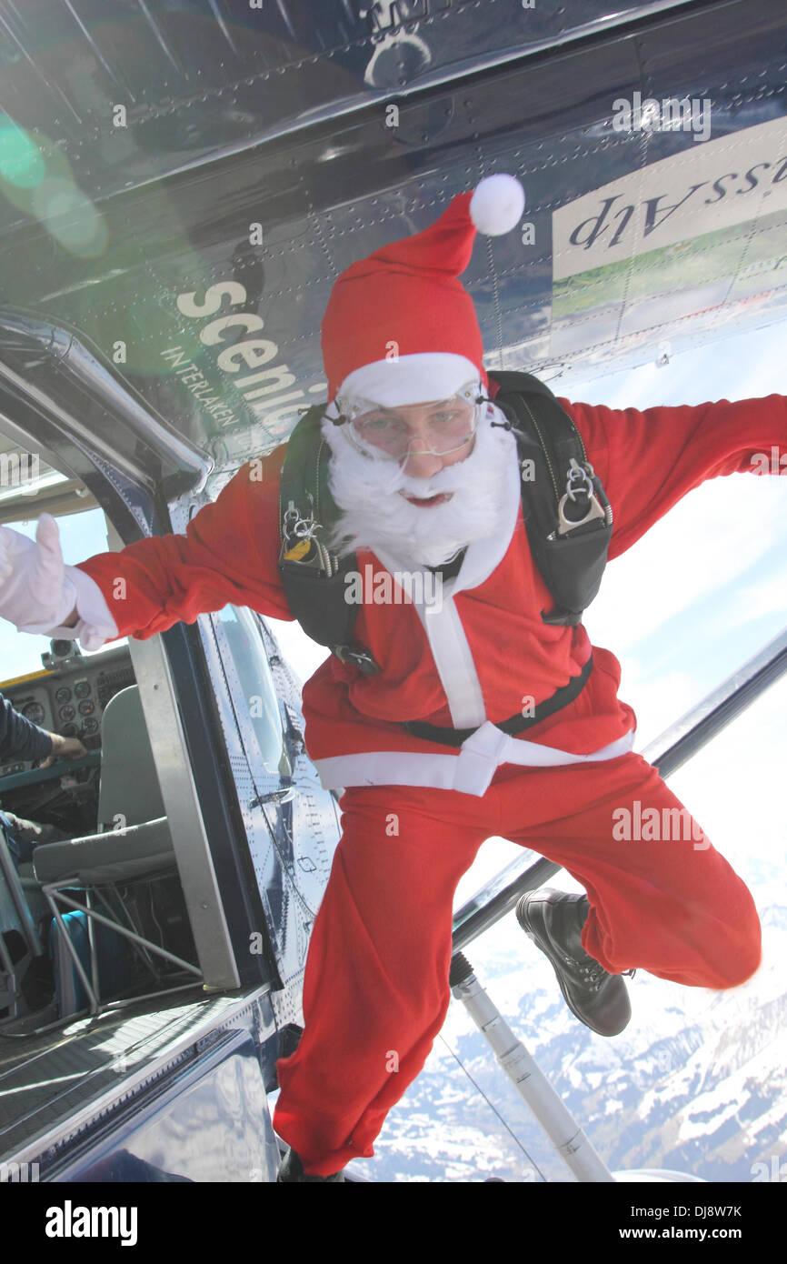 Ce parachutiste dans un costume de Père Noël saute d'un avion au cours d'une position sur le ciel bleu. Banque D'Images