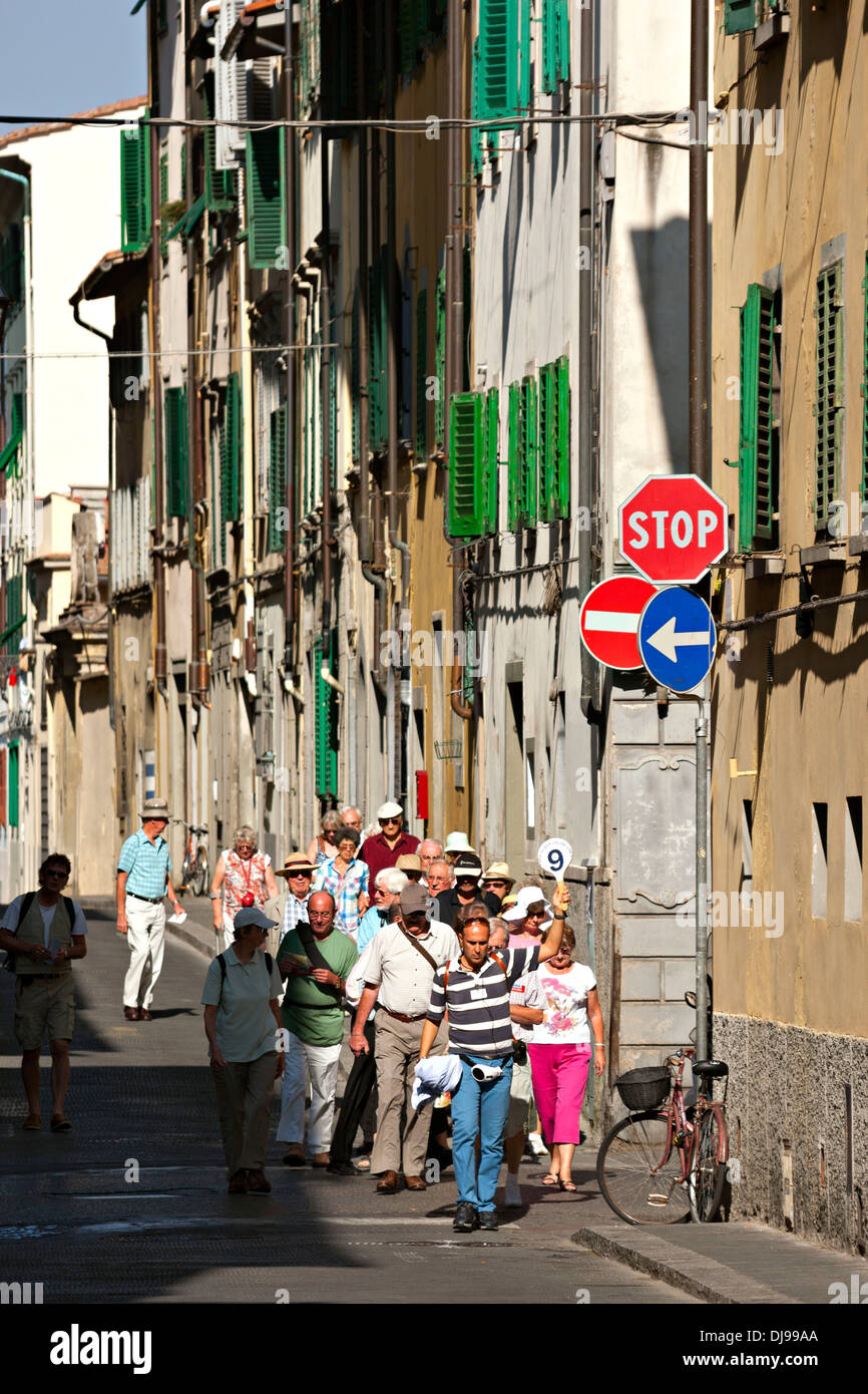 Groupe touristique avec guide mâle tenant une pagaie avec numéro 9, Florence, Italie Banque D'Images