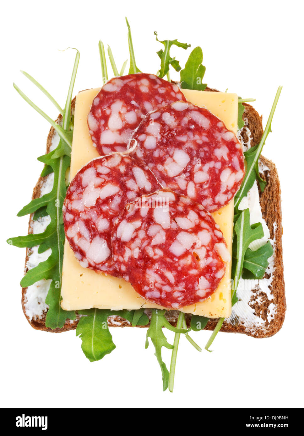 Sandwich de pain brun, salami, fromage et roquette fraîche isolé sur fond blanc Banque D'Images