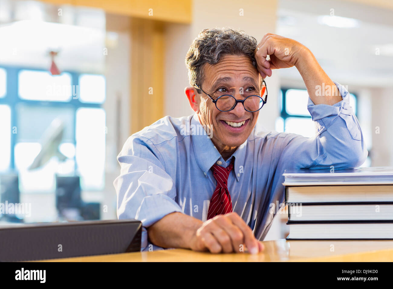 Senior man smiling in library Banque D'Images