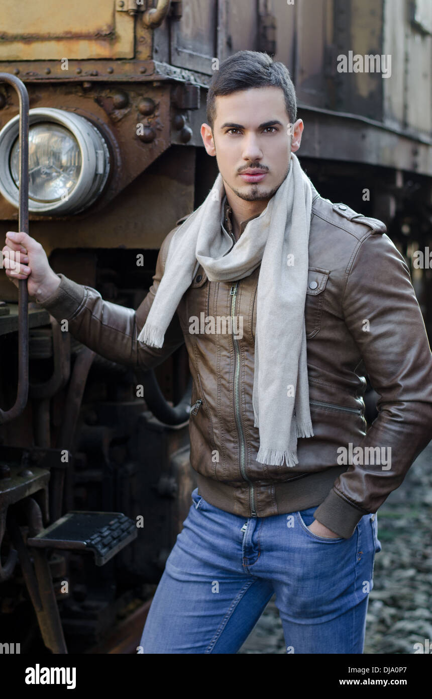 Beau jeune homme en jeans et blouson de cuir à côté de vieux train looking  at camera Photo Stock - Alamy