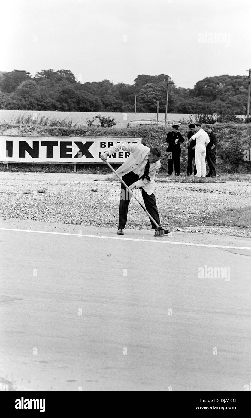 Prévôt balayant le suivi entre les races au Tourist Trophy de Goodwood, en Angleterre, 20 août 1960. Banque D'Images