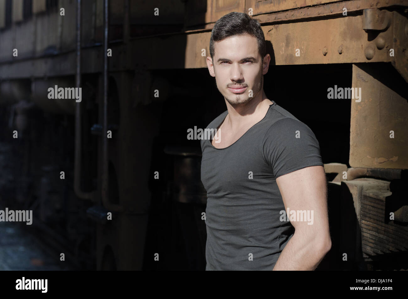 Young Man in Black T-shirt en face de l'ancienne gare looking at camera Banque D'Images