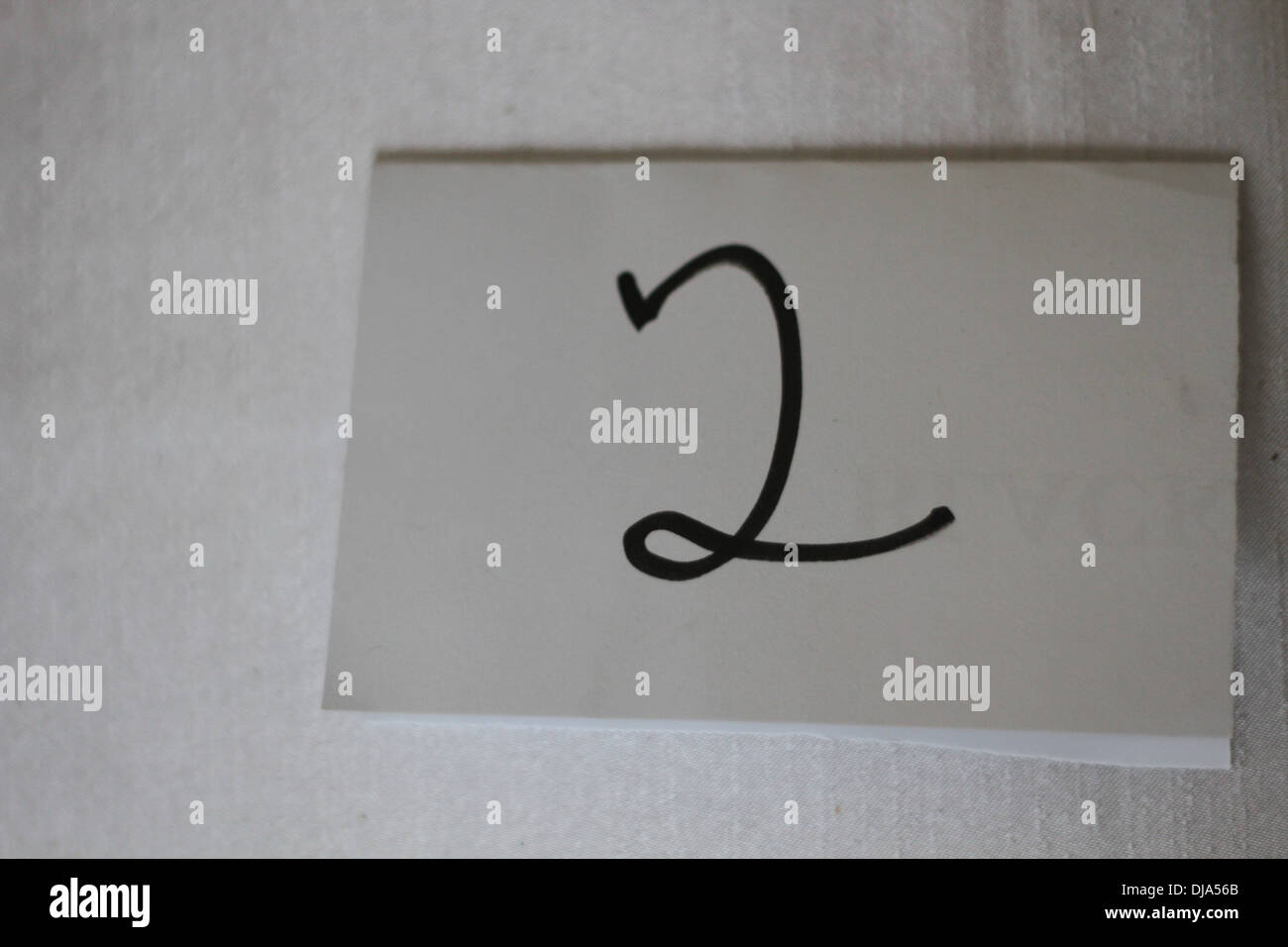 Le nombre 2 écrit sur un morceau de papier. Banque D'Images