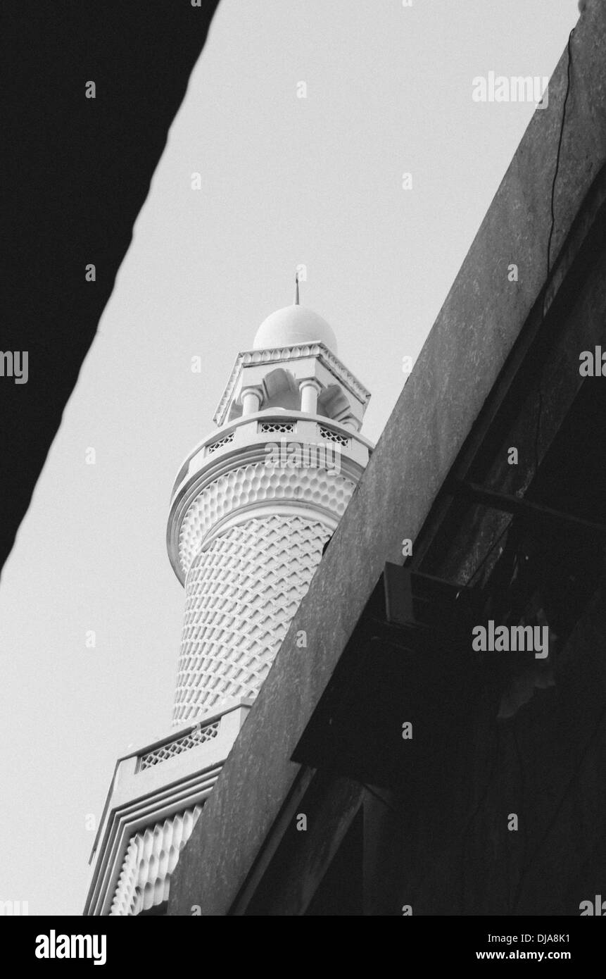 Le minaret d'une mosquée entre les rues étroites du quartier de Deira. Dubaï, Émirats arabes unis. Banque D'Images