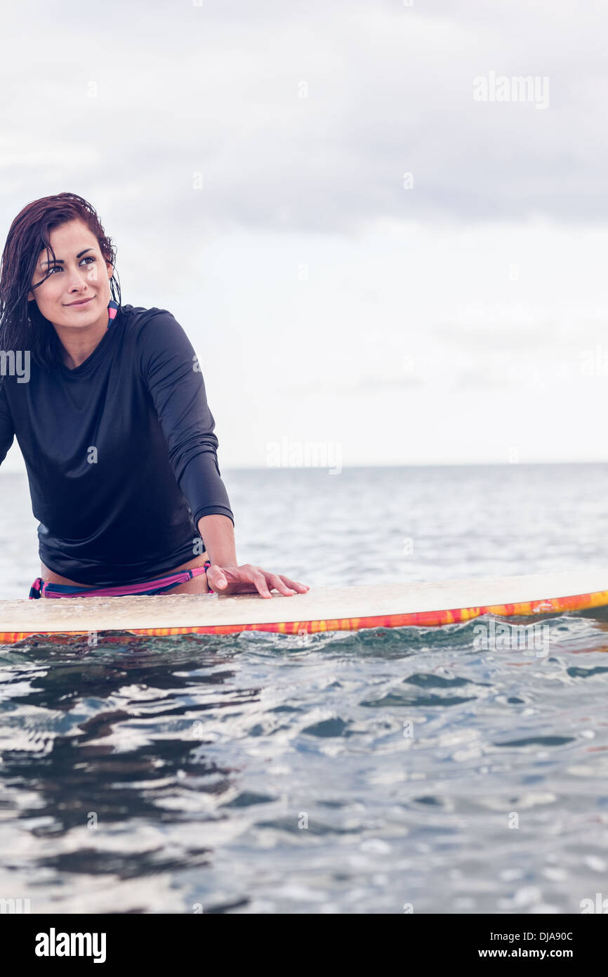 Belle jeune femme holding surfboard at Beach Banque D'Images