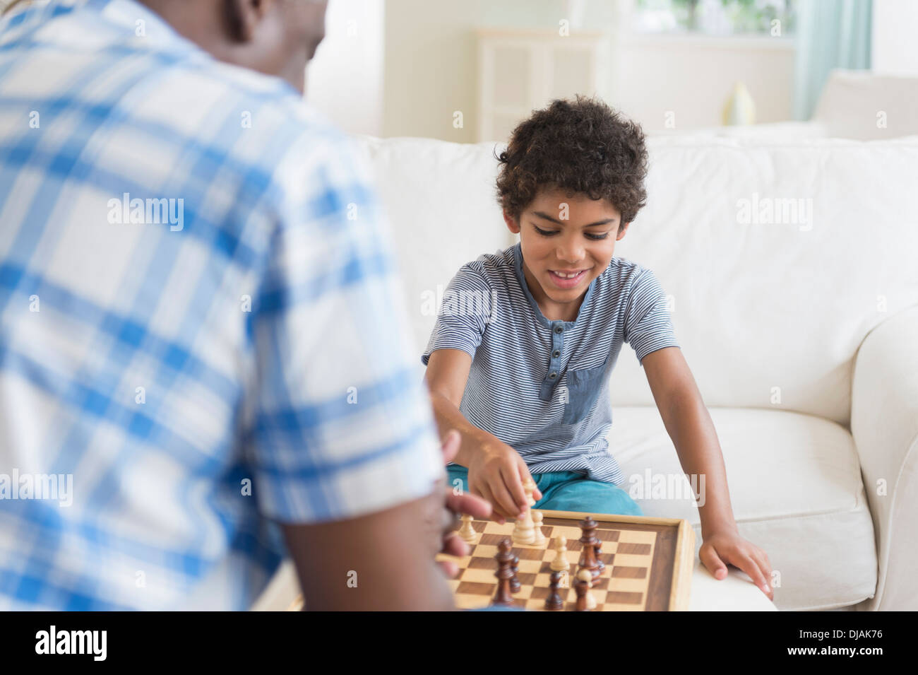Garçon jouant aux échecs avec son grand-père Banque D'Images