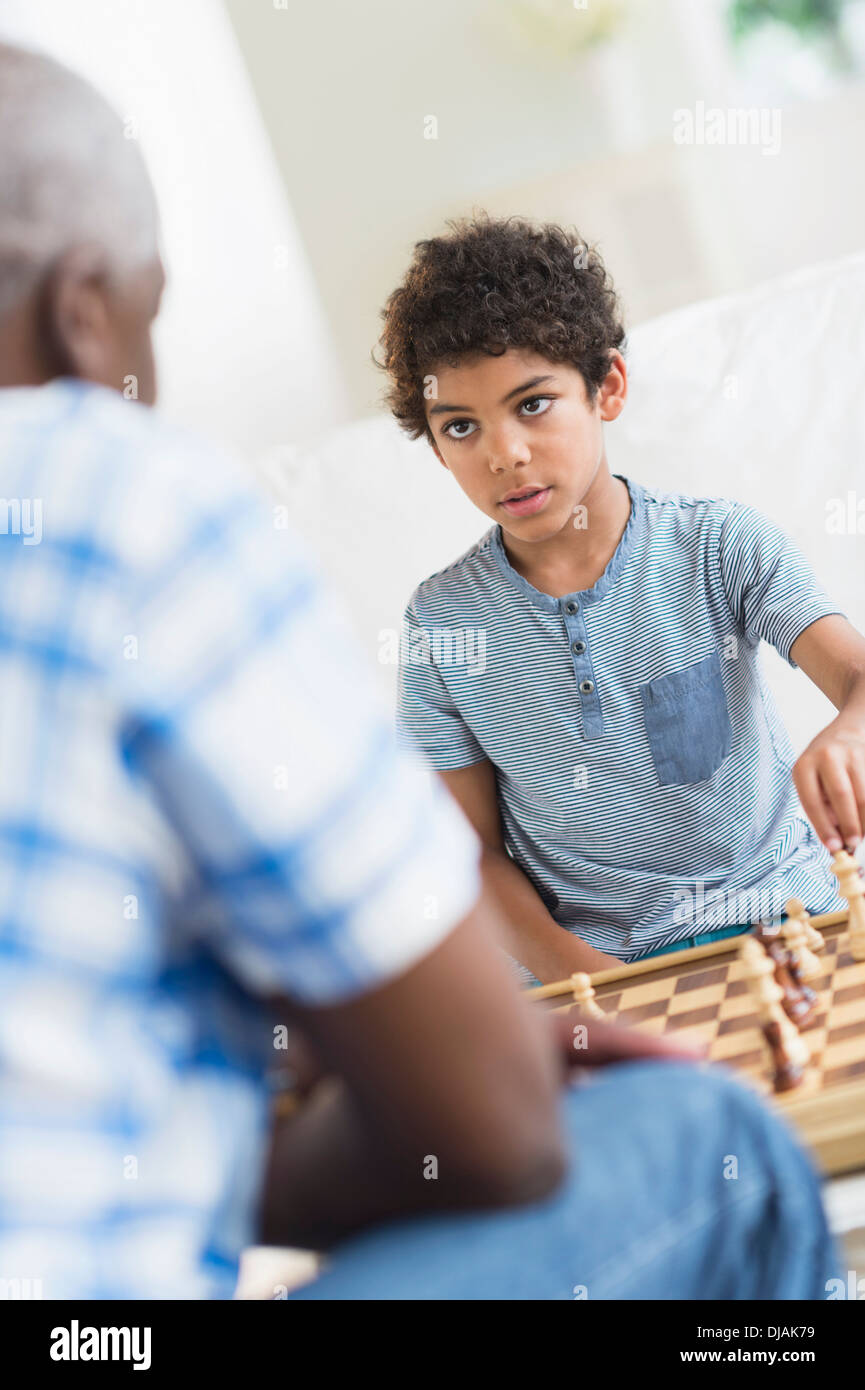 Garçon jouant aux échecs avec son grand-père Banque D'Images