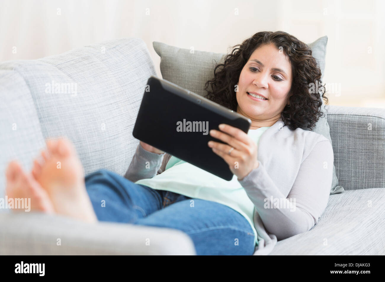 Hispanic woman sitting on sofa Banque D'Images