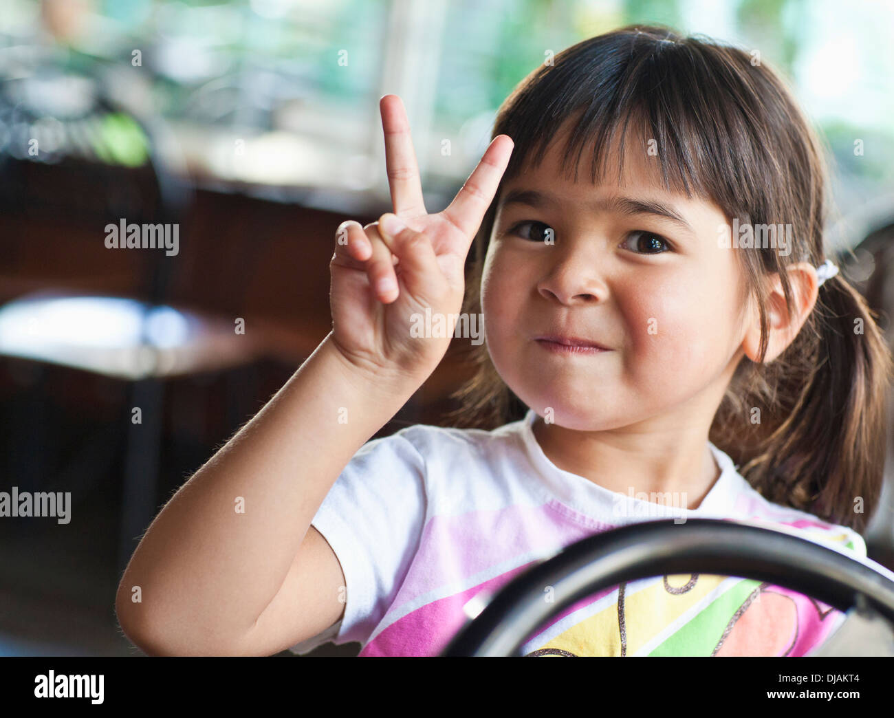 Asian girl making peace sign Banque D'Images