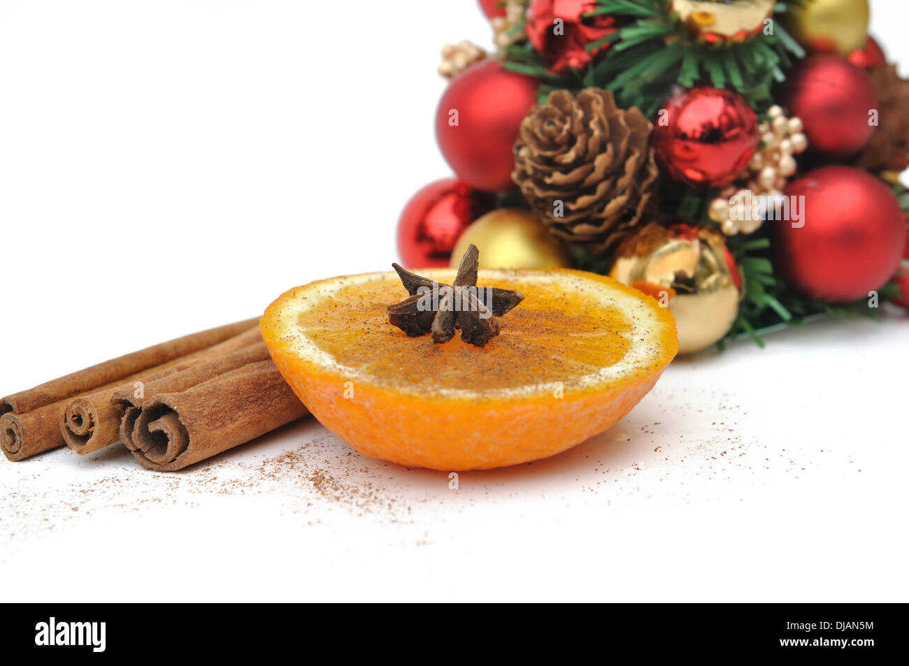 Tranche d'orange et d'épices parmi les décorations de Noël sur fond blanc Banque D'Images