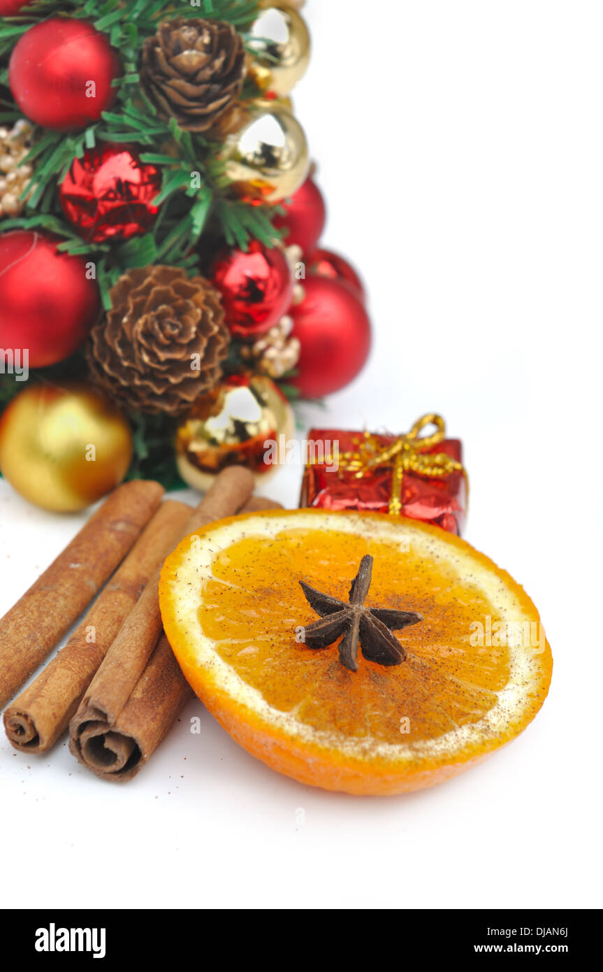 Tranche d'orange et d'épices parmi les décorations de Noël sur fond blanc Banque D'Images