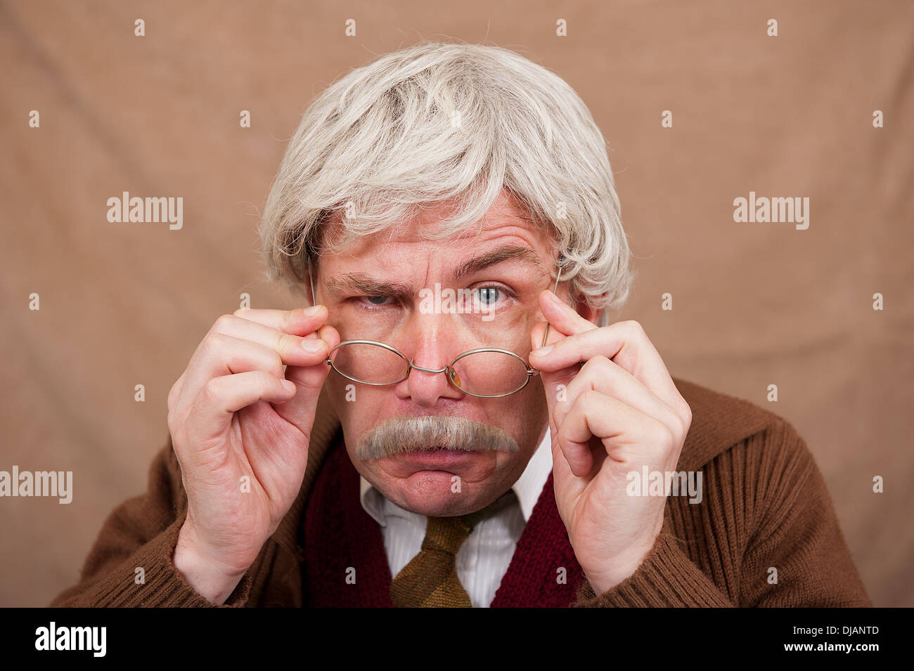 Vieil homme aux cheveux gris réglage de ses lunettes pour mieux voir. Banque D'Images