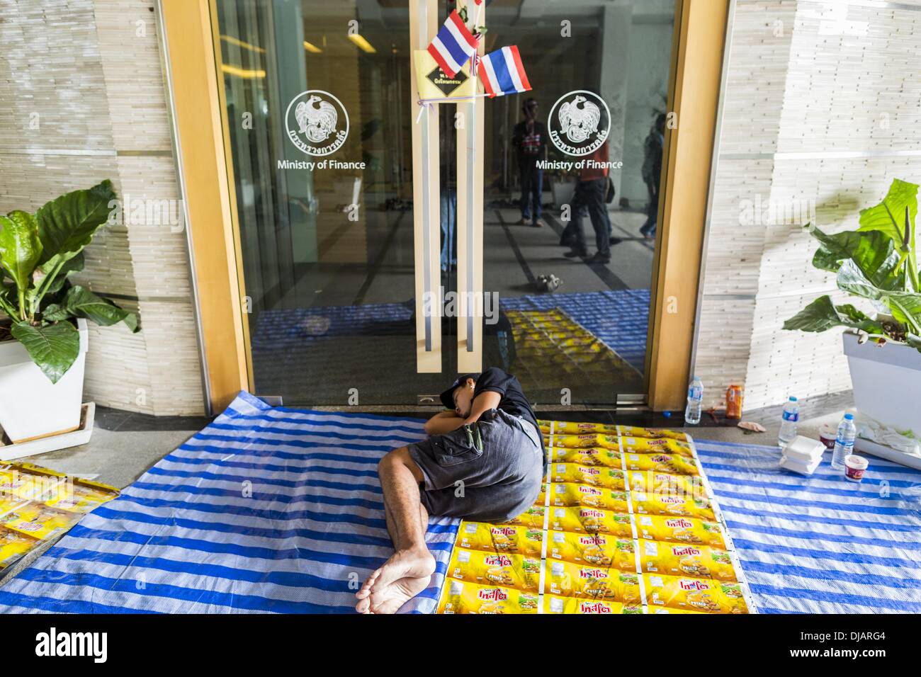 Bangkok, Thaïlande. 26 nov., 2013. Un manifestant anti-gouvernement dort devant le ministère des Finances. Les manifestants opposés au gouvernement du Premier Ministre thaïlandais Yingluck Shinawatra distribués par Bangkok cette semaine. Les manifestants ont pris le contrôle du ministère des Finances, ministère des Sports et du tourisme, ministère de l'intérieur et d'autres plus petits ministères. Les protestataires exigent la démission du Premier Ministre. Credit : ZUMA Press, Inc./Alamy Live News Banque D'Images