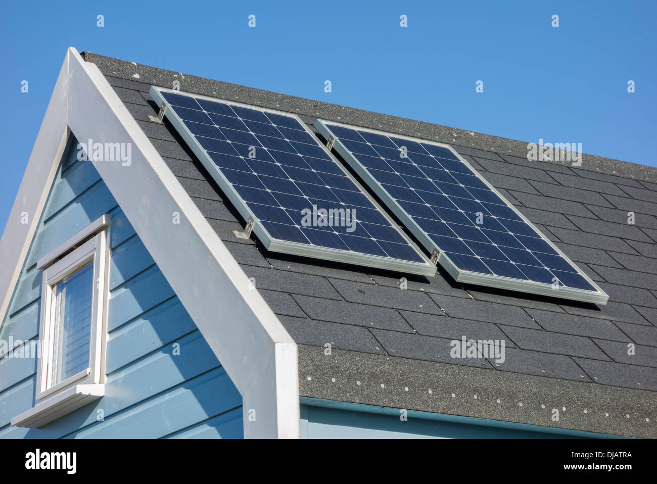 Des panneaux solaires sur toit de cabane de plage, Christchurch Harbour, Dorset, England, UK. Banque D'Images