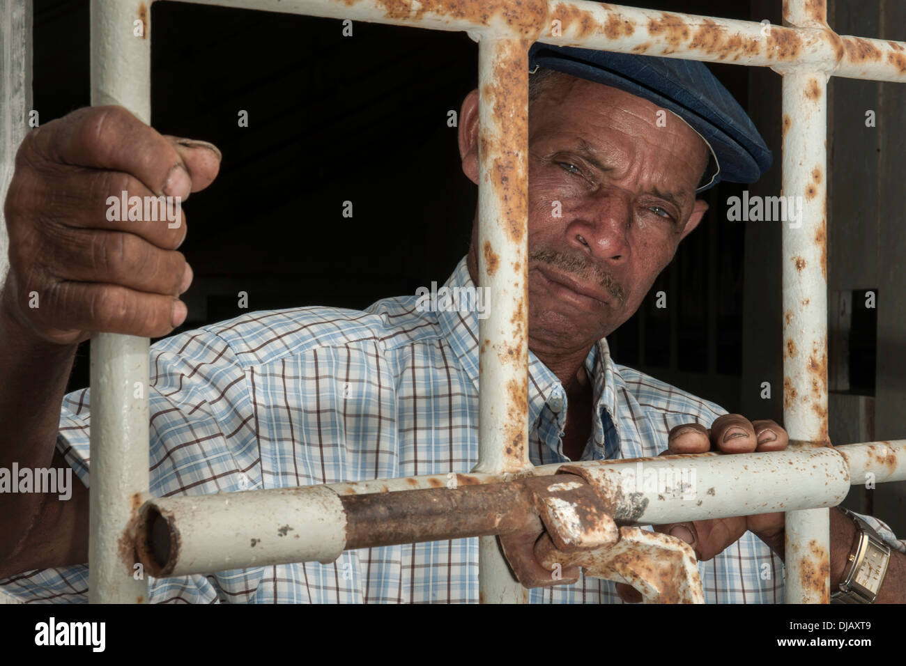 Un ancien prisonnier debout derrière une porte avec des barres de fer, l'ancien camp de concentration de Tarrafal ou Campo do Tarrafal, Tarrafal Banque D'Images