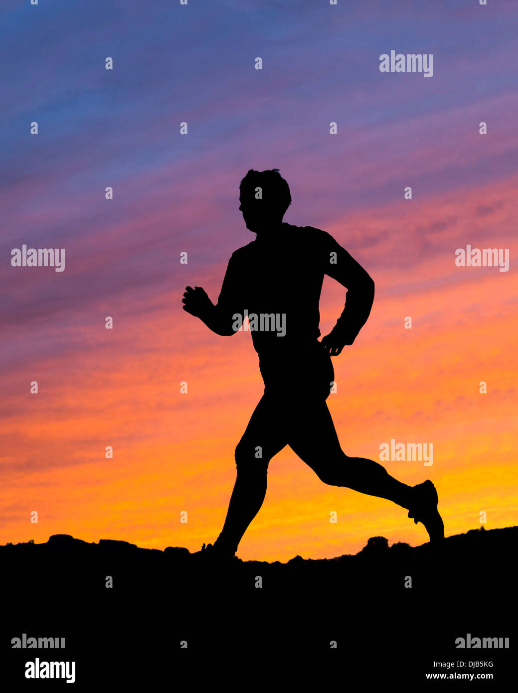 Silhouette d'un jogger au coucher du soleil Banque D'Images