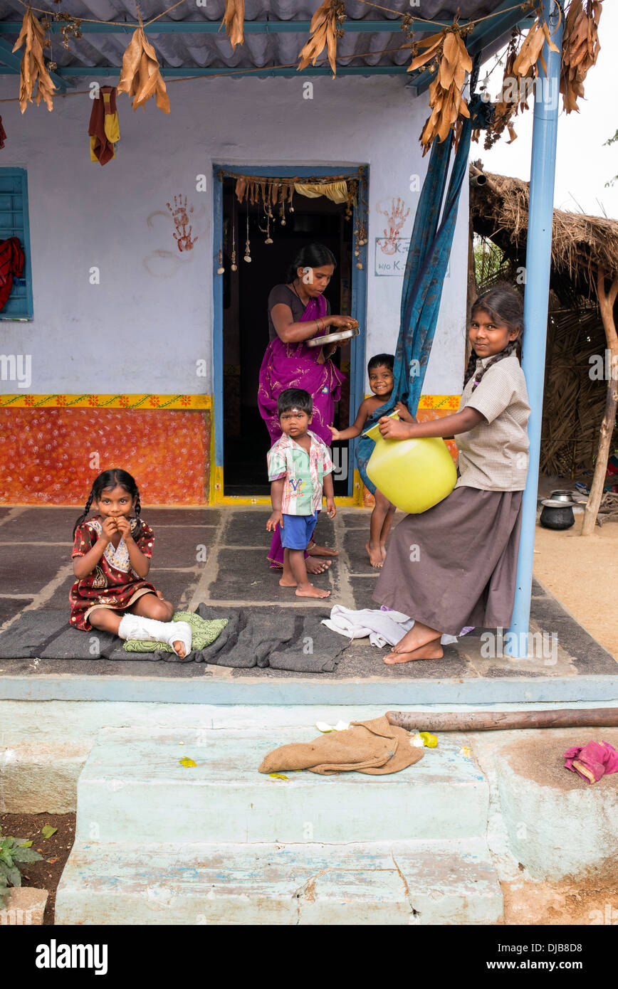 Indian girl with jambe cassée et à la famille en dehors de leur village de l'Inde rurale accueil. L'Andhra Pradesh, Inde Banque D'Images