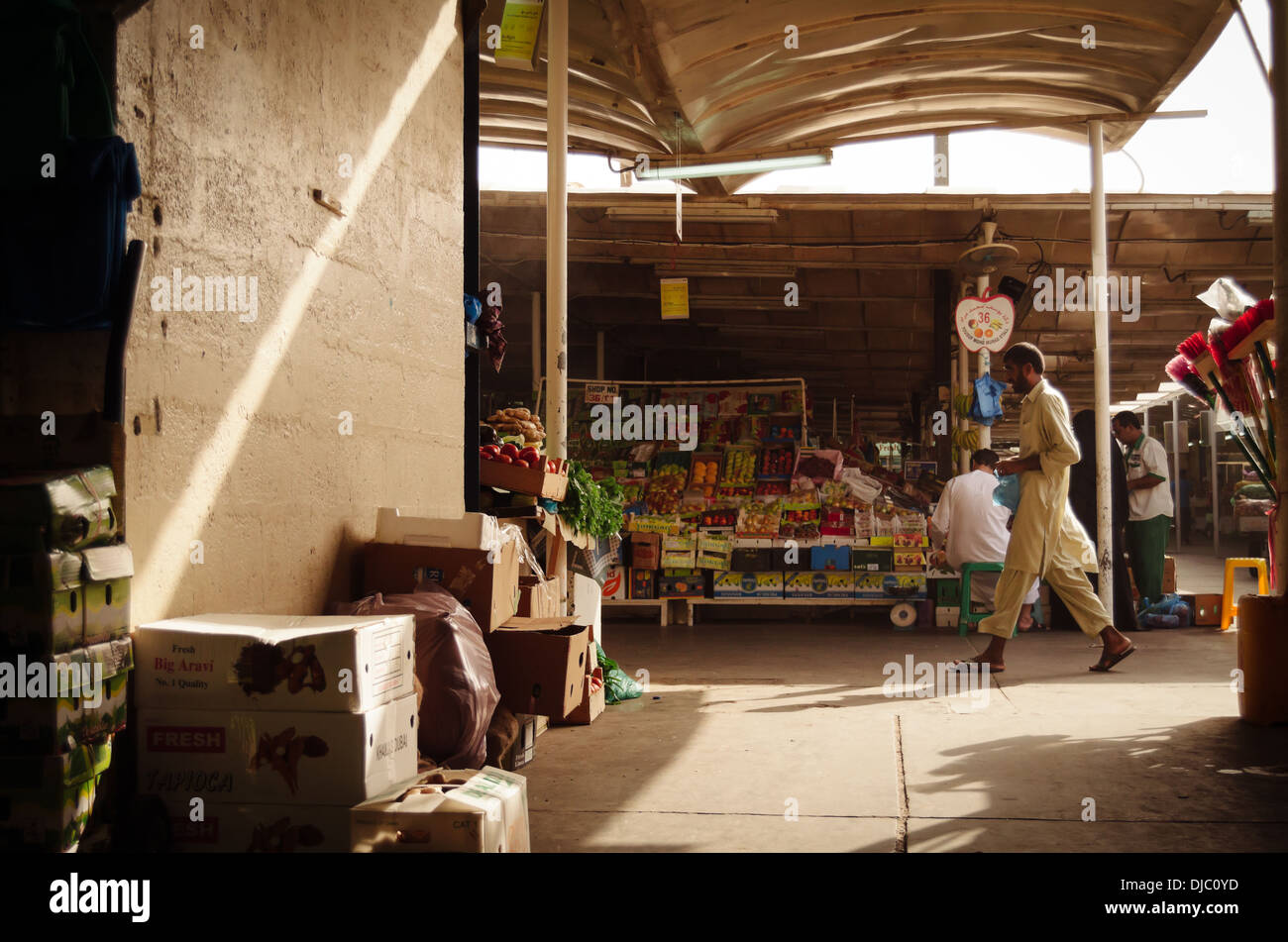 Un homme marche le long d'un des pays arabes les couloirs du Deira au marché de fruits et légumes. Dubaï, Émirats arabes unis. Banque D'Images