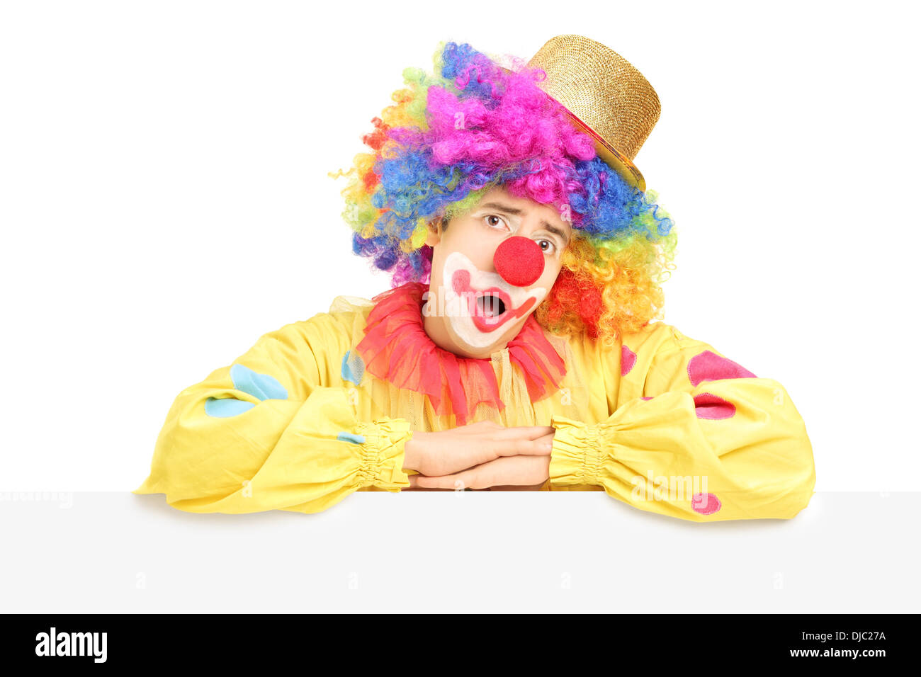 Homme clown de cirque faisant une grimace sur un panneau vierge Banque D'Images