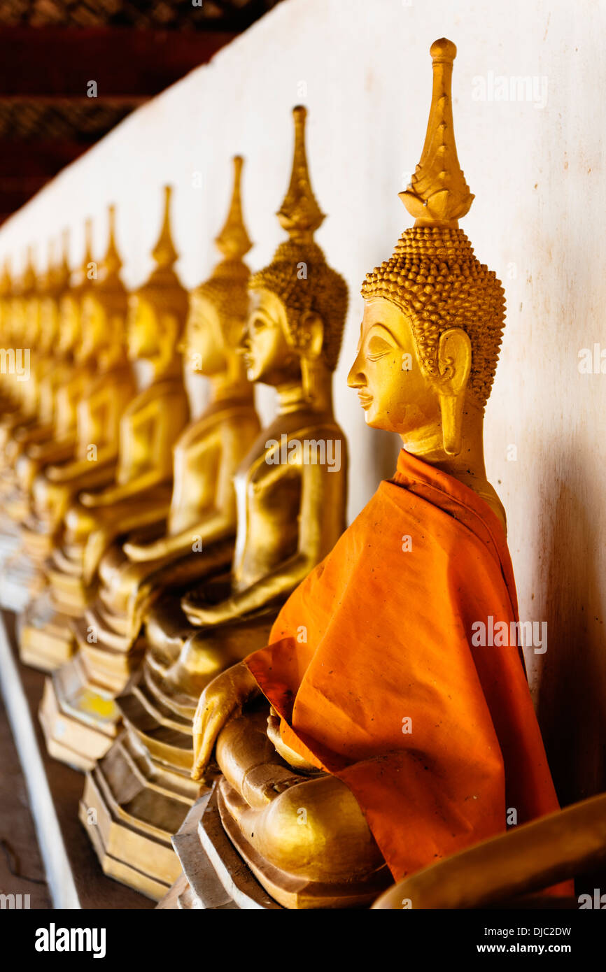 Une ligne de statues de Bouddha doré à accrocher à ce Temple, Savannakhet, Laos. Banque D'Images