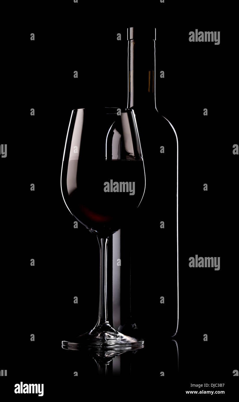 Verre et bouteille de vin rouge sur fond noir Banque D'Images