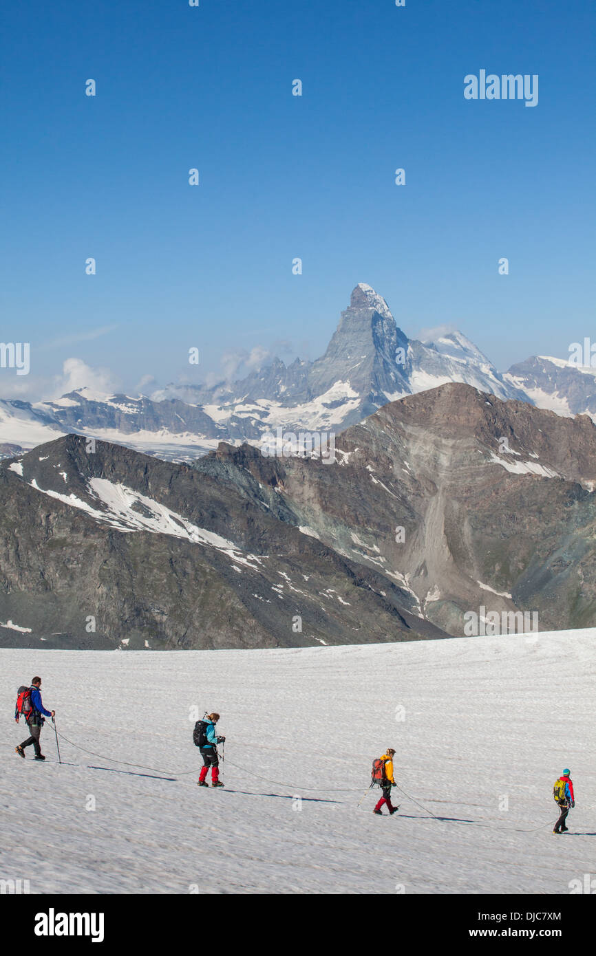 Un premier guide ses clients sur le glacier dans les Alpes suisses, en face de la Matterhorn Banque D'Images