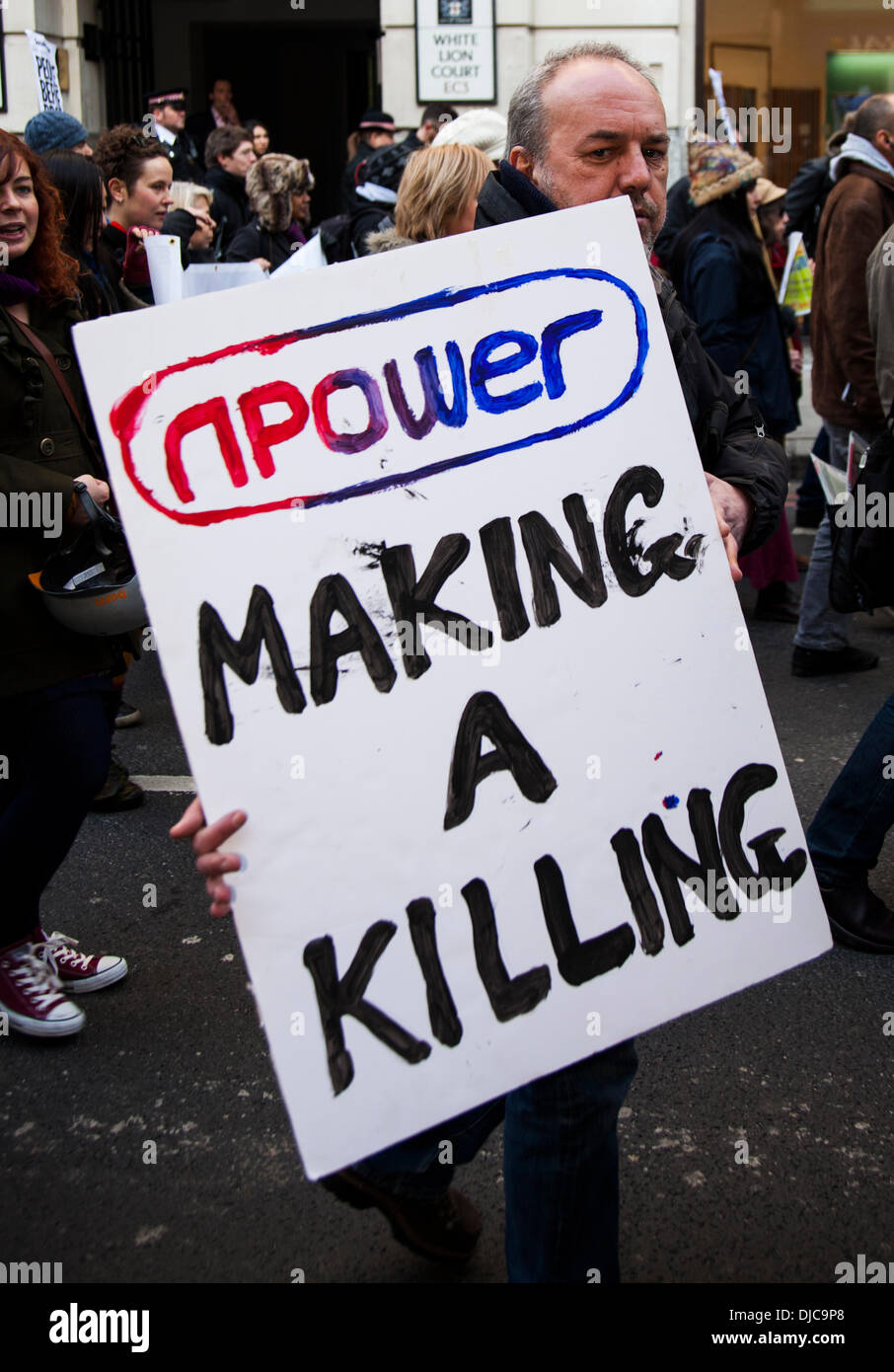 London, UK . 26 nov., 2013. Un manifestant tient le haut d'une bannière "npower faire un massacre" lors d'une manifestation contre la pauvreté énergétique qui ciblait Npower bureau de London, Londres, Royaume-Uni le mardi 26 novembre 2013. Credit : Redorbital Photography/Alamy Live News Banque D'Images