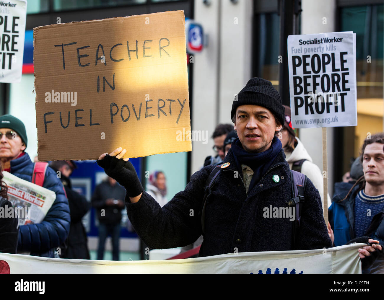 London, UK . 26 nov., 2013. Un manifestant est titulaire d'une lecture de la bannière "enseignant dans la pauvreté énergétique' lors d'une manifestation contre la pauvreté énergétique qui ciblait Npower bureau de London, Londres, Royaume-Uni le mardi 26 novembre 2013. Credit : Redorbital Photography/Alamy Live News Banque D'Images
